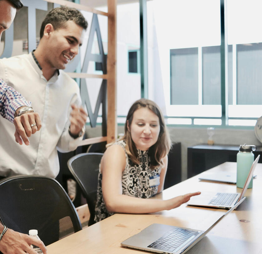 Employees employees gathered around in front of computer